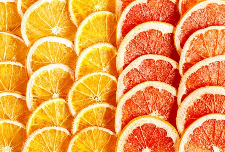 diferentes tipos da fruta cortada ao meio representando a história da laranja