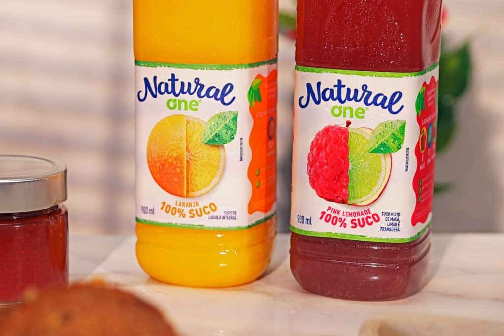 Texto Alternativo - Na foto há duas garrafas de suco de Natural One, sabor laranja e pink lemonade.