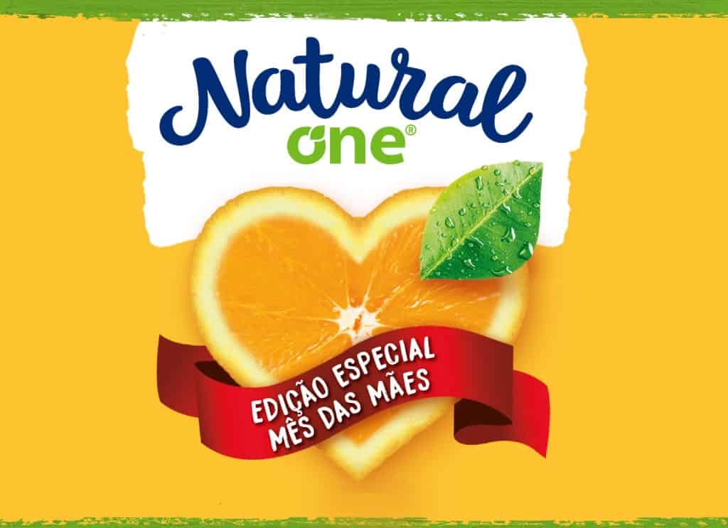 Texto alternativo - A imagem mostra o rótulo do suco de laranja da Natural One da embalagem especial de dia das mães. No centro há um laranja no formato de coração.