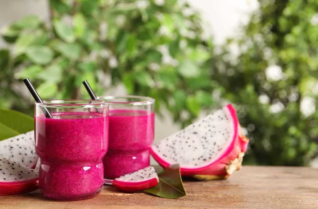 Texto alternativo: Na imagem há dois copos com Smoothie de pitaya e manga com Bebida de Aveia sabor Frutas Vermelhas