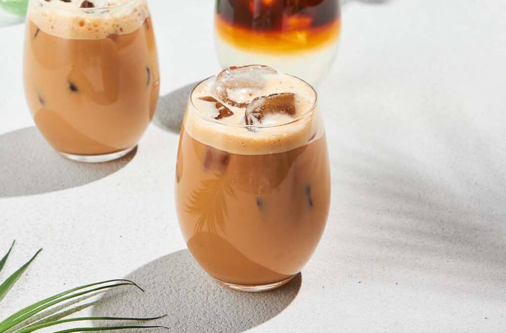 Texto alternativo: na imagem há dois copos com Café latte com Bebida de Aveia sabor Cappuccino