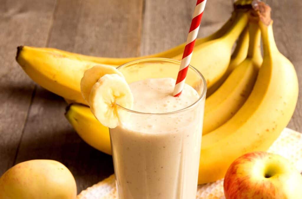 Texto alternativo: na imagem há um copo com vitamina de banana deita com bebida vegetal 