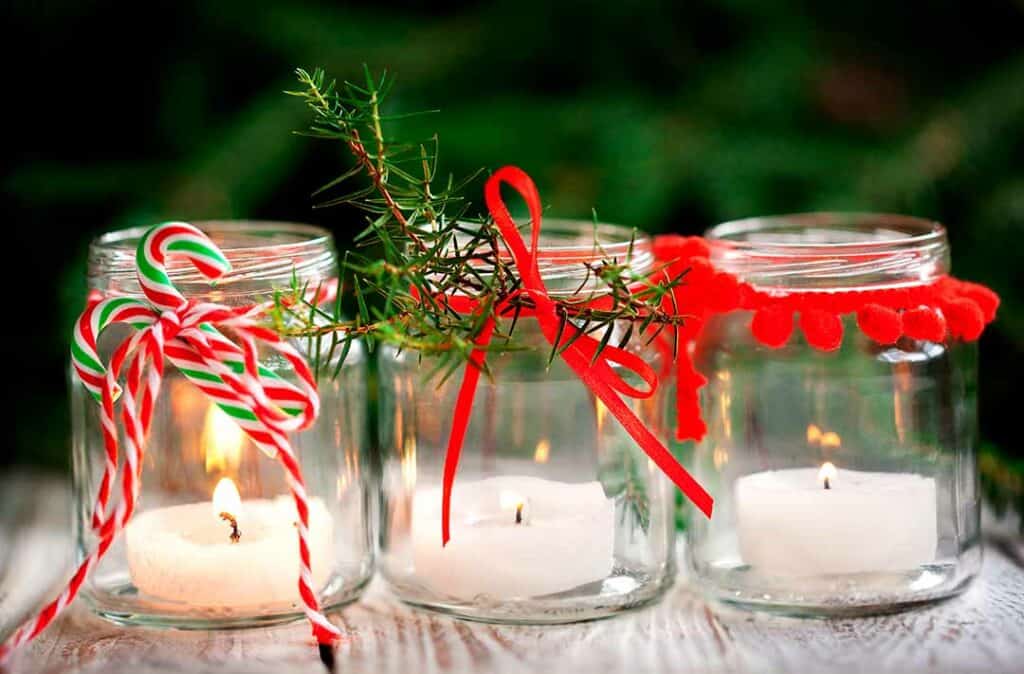 texto alternativo: na imagem há potes de velas decoradas para o natal para celebrar as festa de fim de ano