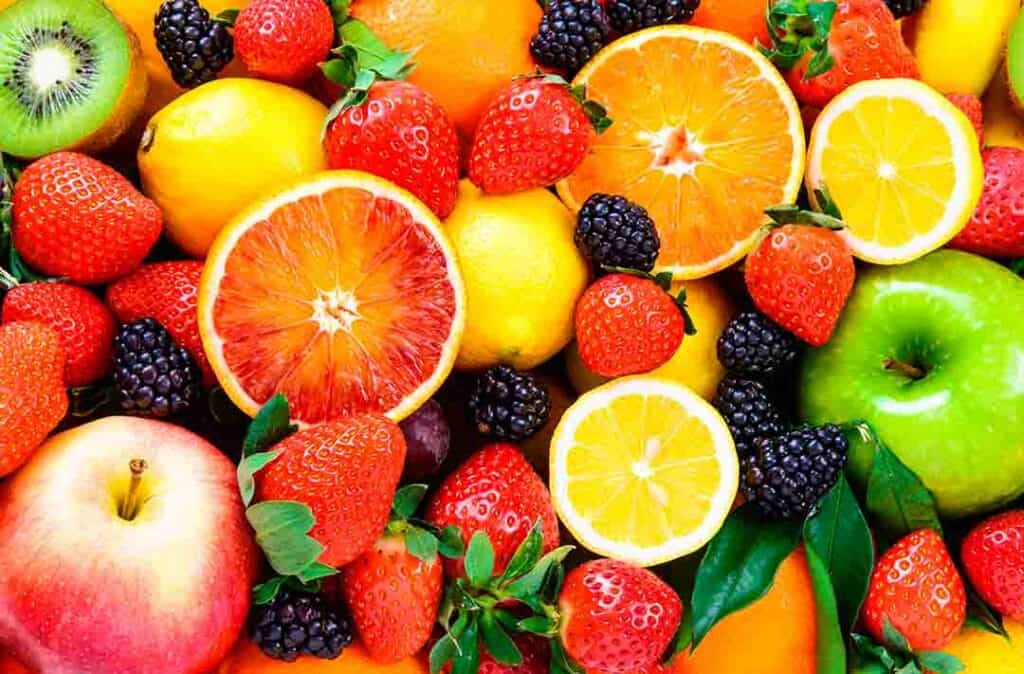 Texto alternativo: na imagem há várias frutas juntas, laranja, morango, amora, maçã